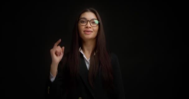 Businesswoman points directly at the camera chooses you on a black background. — Stock Video