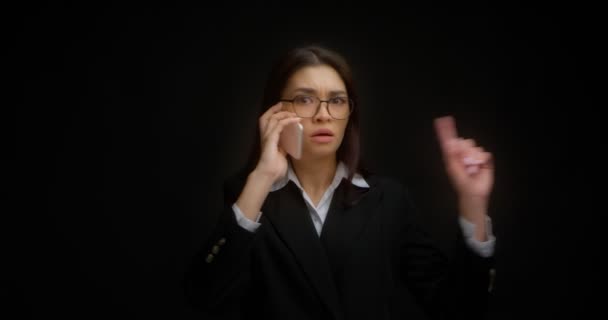 Woman is talking on the phone and raises her index finger up, says no. — Stock Video