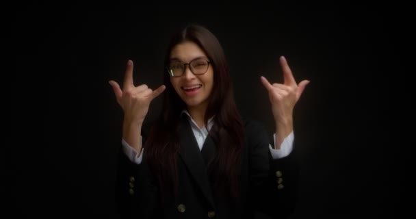 Jong mooi zakenvrouw toont een rock symbool met haar handen. — Stockvideo