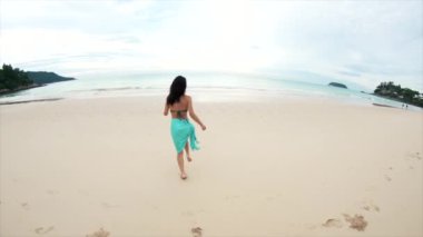 Denize koşan mutlu genç bir gezgin kız. Tayland 'da turizm ve eğlence. Yakışıklı Asyalı kadın adaları geziyor. Kız hayattan zevk alıyor ve eğleniyor. Cennet kumsalları ve beyaz kum