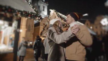 Prag 'da gece meydanında dans eden mutlu çift. Aşk, aile, Noel, yeni yıl, tatil konsepti. RED kamera, 10 bit klonlama