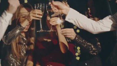 Birlikte dinlenen, şampanya tokuşturan genç adamların mutlu yüzleri. Yılbaşını, Noel 'i ya da Noel' i kutlayan havai fişeklerle partilerde ya da kutlamalarda.