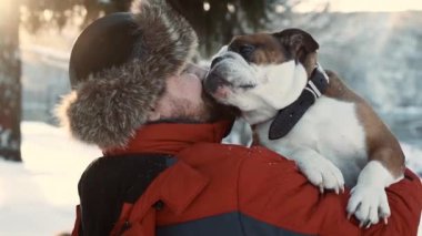 Sakallı adam kış güneşli bir günde köpeğine sarılıyor. Arkadaşlık, xmas, kış, evcil hayvan konsepti.