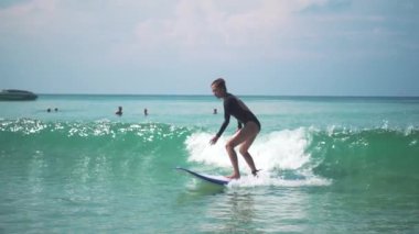 Bikinili güzel esmer kadın sörf yapıyor.