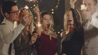 Çocuklar havai fişek sallayarak, yılbaşı ya da Noel arifesinde eğlenerek kutluyorlar. Kapalı portre arkadaşları maytapları ellerinde tutuyorlar. Mutlu bir grup insan akşamları eğleniyor..