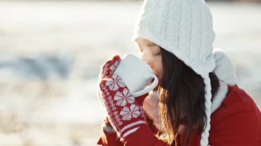 Kış sabahı parmaklarıyla aşk yapan bir kadın. Gün batımının parıltısı ellerinde. Güneş ışınları parlıyor. Tatil zamanı. Aşk sembolleri