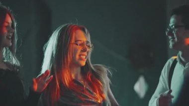 Doğum gününde, yeni yılda, Noel 'de ya da Xmas partisinde dans eden çok ırklı genç hippi arkadaşlarının yakın çekimi. Mutlu, gülümseyen adamlar renkli ışıklarla süslenmiş evin önünde birlikte eğleniyorlar..