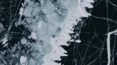 Baykal Gölü 'nde kayan adamın buzla kaplı görüntüsü. Erkek sporcu, soğuk havada, gökyüzü ve bulutlar gölün güzel buzlu yüzeyine yansıyor..