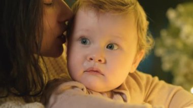 Anne ve bebek atlıkarıncada atlarla oynuyorlar. Aile Kış Gecesini Evde Geçiriyor. Küçük Çocuk 'la Genç Anne oynuyor. Ağır çekim. Noel, Yeni Yıl, Kış Tatili Kutlaması. 4K 10 bit renk