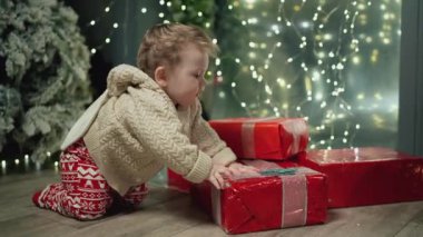 Bebek mutlu yıllar geçirdiği için mutlu. Aile Kış Gecesini Evde Geçiriyor. Küçük Çocuk 'la Genç Anne oynuyor. Ağır çekim. Noel, Yeni Yıl, Kış Tatili Kutlaması. 4K 10 bit renk