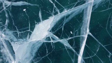 Donmuş Baykal Gölü, hava manzaralı. Pürüzsüz buzla güzel bir kış manzarası. Rusya 'nın ünlü doğal simgesi. Derin çatlakları olan mavi şeffaf buz, donmuş bir göl manzarası..