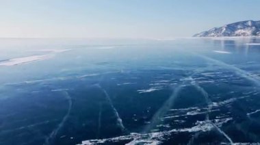 Donmuş Baykal Gölü, hava manzaralı. Pürüzsüz buzla güzel bir kış manzarası. Rusya 'nın ünlü doğal simgesi. Derin çatlakları olan mavi şeffaf buz, donmuş bir göl manzarası..