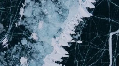 Baykal Gölü 'nde kayan adamın buzla kaplı görüntüsü. Erkek sporcu, soğuk havada, gökyüzü ve bulutlar gölün güzel buzlu yüzeyine yansıyor..