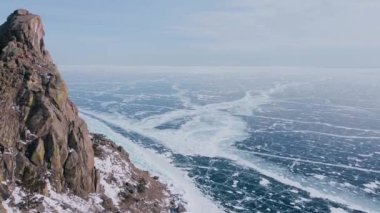 Donmuş Baykal Gölü, hava manzaralı. Pürüzsüz buzla güzel bir kış manzarası. Rusya 'nın ünlü doğal simgesi. Derin çatlakları olan mavi şeffaf buz, donmuş bir göl manzarası..