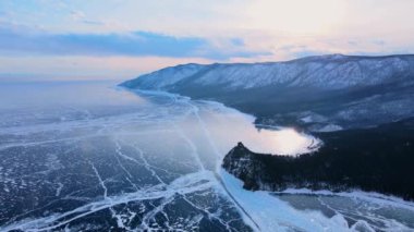 Donmuş Baykal Gölü, hava manzaralı. Pürüzsüz buzla güzel bir kış manzarası. Rusya 'nın ünlü doğal simgesi. Derin çatlakları olan mavi şeffaf buz, donmuş bir göl manzarası..