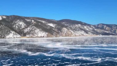 Donmuş Baykal Gölü, hava manzaralı. Pürüzsüz buzla güzel bir kış manzarası. Rusya 'nın ünlü doğal simgesi. Derin çatlakları olan mavi şeffaf buz, donmuş bir göl manzarası..