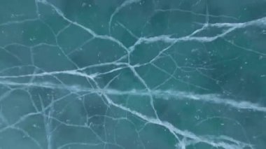 Donmuş Baykal Gölü, hava manzaralı. Pürüzsüz buzla güzel bir kış manzarası. Rusya 'nın ünlü doğal simgesi. Derin çatlakları olan mavi şeffaf buz, donmuş bir göl manzarası..