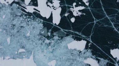 Donmuş Baykal Gölü, hava manzaralı. Pürüzsüz buzla güzel bir kış manzarası. Rusya 'nın ünlü doğal simgesi. Derin çatlakları olan mavi şeffaf buz, donmuş bir göl manzarası..