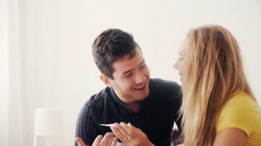 Müstakbel ebeveynler bebek bekliyor. Mutlu genç kız sevgilisine pozitif hamilelik testiyle sürpriz yapıyor. Aşk kavramı, aile, ilişki. Hamileliğin neşesi. Heyecanlı çift, geleceğin çocuğunu bekliyor..