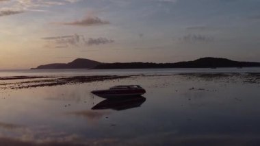 Sürat teknesi güney Phuket 'te akıntıyla karaya vurmuş, insansız hava aracı sığ kıyılarda uçuyor.