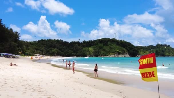 タイのビーチで観光客 観光客が歩くとプーケットのナイ ハーンの南の砂浜でリラックス — ストック動画
