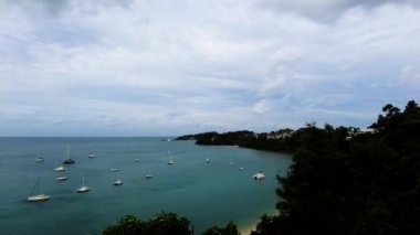 Bir deniz tropikal körfezinin zamanının tersine dönmesiyle, yelkenli tekneleri demirlemiş, birçok tekne körfezde demirlemiş durumda.