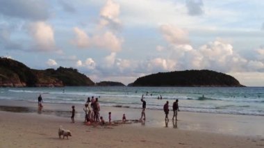 Birçok çocuk deniz kıyısında kumla oynar, çocuklar akşamları Tayland 'da Phuket' te deniz kıyısında.