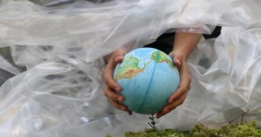 Küre ve plastik film yeşil orman, çevrenin kirliliği. Plastiğin geri dönüşümü sorunu. Çevreyi Kurtarın. Yüksek kalite fotoğraf