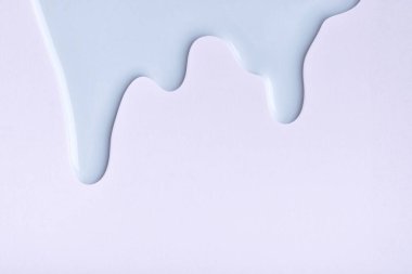 Açık mavi renkli boya damlaları gri arkaplanda akıyor. Soyut gökyüzü arkaplanı ve akışkan damlalar. Kopya alanı olan akrilik resim.