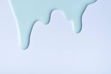 Açık mavi renkli boya damlaları gökyüzü arka planına akar. Soyut arkaplan, turkuaz sıvı damlası desenli. Kopya alanı olan akrilik resim.