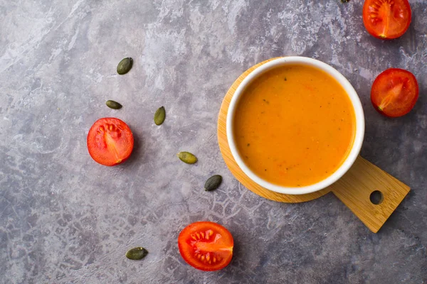 Vejetaryen havuç çorbası, gri beton arka plan, üst manzara.