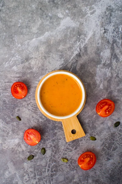 Vejetaryen havuç çorbası, gri beton arka plan, üst manzara.