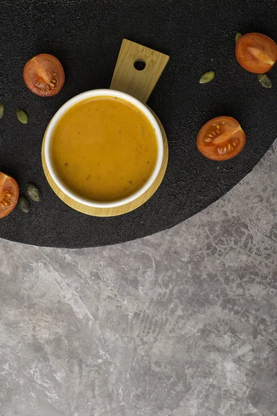 Vejetaryen balkabağı çorbası, siyah arka planda, üst manzara.