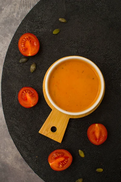 Vejetaryen balkabağı çorbası, siyah arka planda, üst manzara.