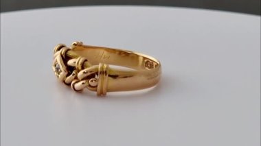 Beyaz zemin üzerinde dönen altın ve elmas düğüm halkası. 3D altın ve elmas düğüm halkası animasyonu. Altın ve elmas düğüm halka hareketli grafikleri. Reklamlar mücevher ve süsler için ürün konsepti.