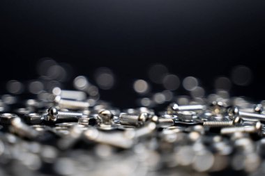 Sürgüleri, vidaları, fındıkları, makineleri, mekanik parçaların yavaş çekimde düşüp zıplamasını kapatın. Siyah arka plan. Hassas iş. Marangoz olarak çalış. Doğrama ve inşaat işleri.