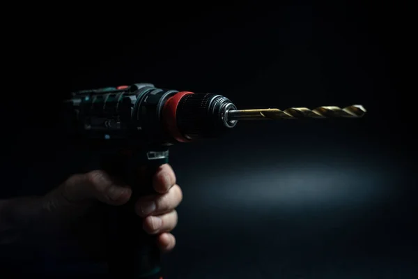 Close up hand drill concept. black background. craftsmanship