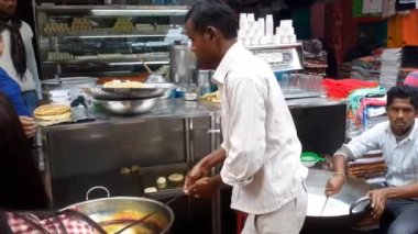 Bir grup Hint sokak yemeği satıcısı Hindistan 'ın Bihar eyaletinde yol kenarında kızartılmış chapatiler yapıyor..