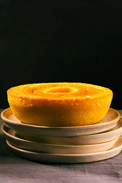 Brazilian Corn Cake (Bolo de Fuba) on a on plates, isolated, close up, vertical, black background, copy space