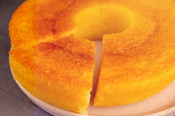 A piece of homemade round Corn Cake, a vegan and healthy delicious cake (Bolo de Fuba), Close Up View