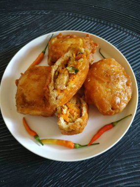 Baharatlı sebze dolgulu kızarmış tofu, siyah arka planda Endonezya 'dan atıştırmalıklar (Tahu Isi Berontak)