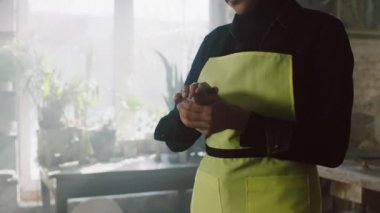 Sarı Önlüklü Kadın Clay 'i şekillendiriyor