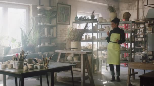 Mujer joven está bailando sola en el estudio de cerámica — Vídeos de Stock