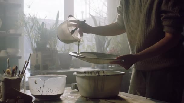 Mujer está cubriendo placa de cerámica con esmalte — Vídeos de Stock