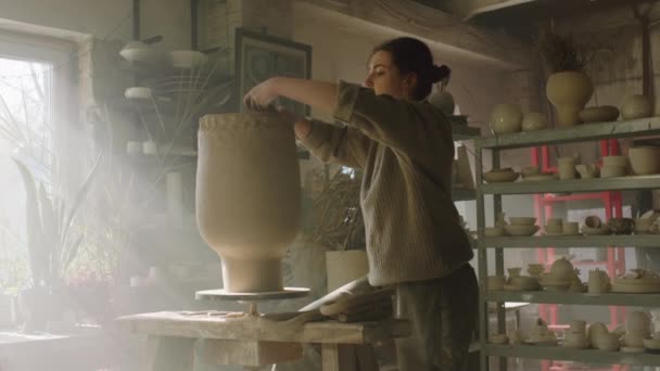 女性はアートスタジオで花瓶を作成しています — ストック動画