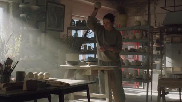 Vrouw plaatst stuk klei op pottenbakkerswiel — Stockvideo