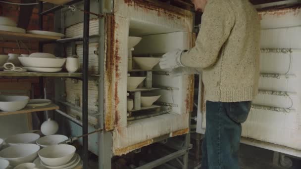 Man Potter está removendo cerâmica do forno — Vídeo de Stock