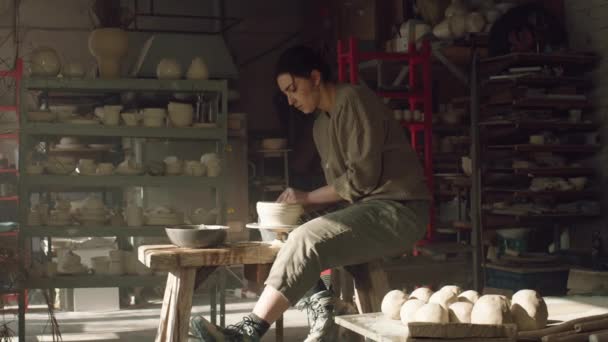 Mujer Potter está sentado en Potters rueda y trabajando — Vídeo de stock