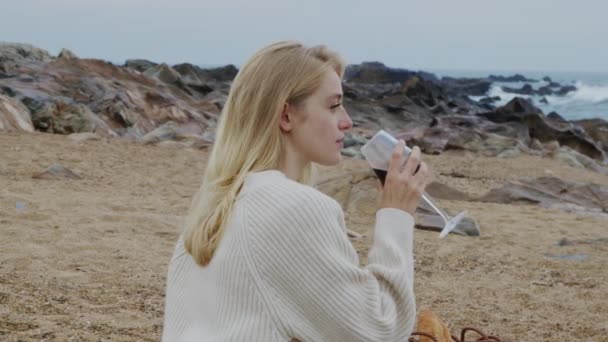 Frau trinkt Wein am Strand — Stockvideo