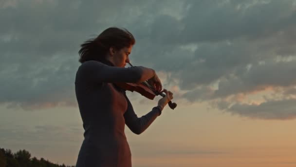 Violinista tocando solo al amanecer — Vídeo de stock